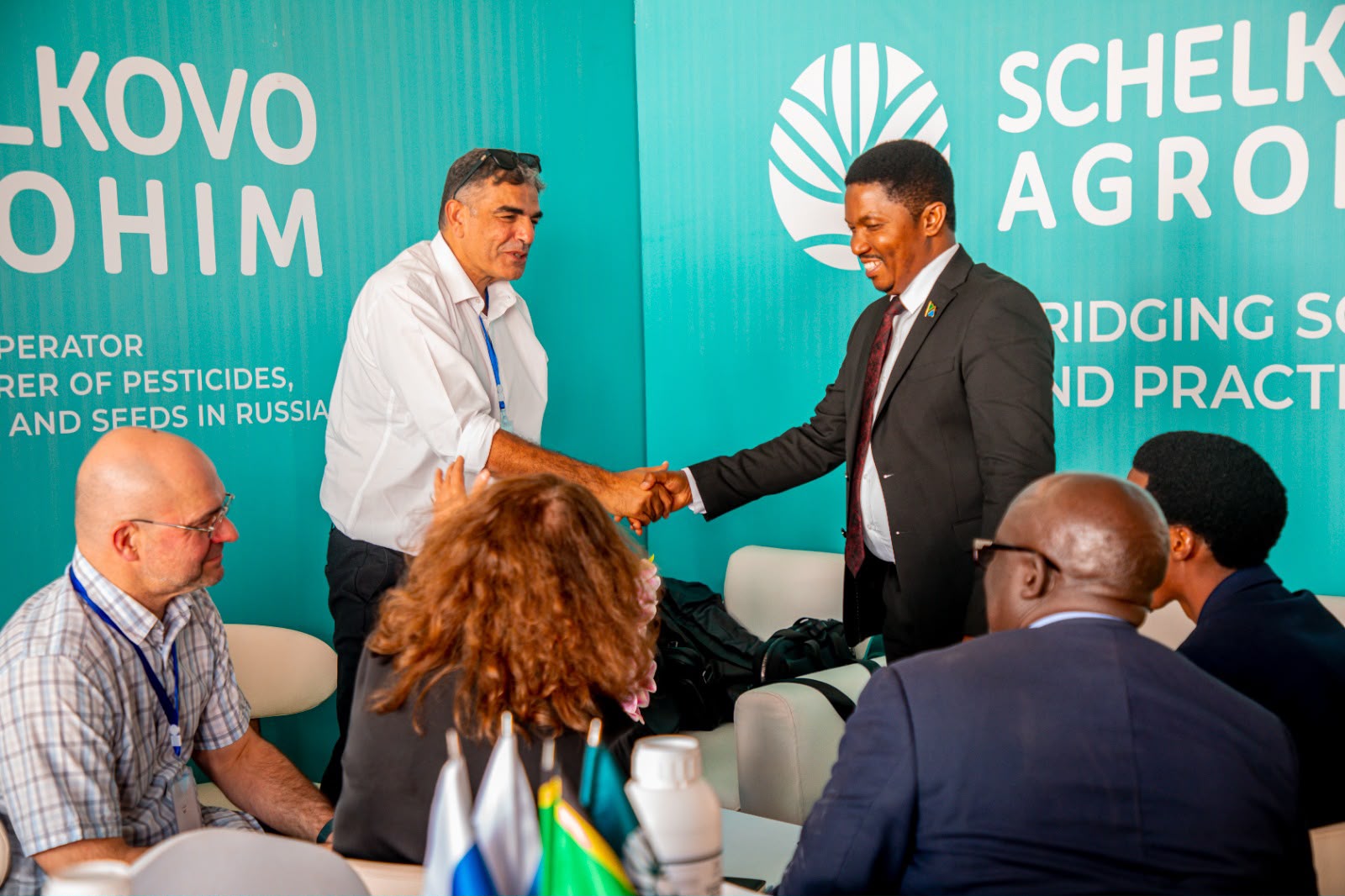 Agricultural representatives shaking hands during a partnership meeting in Tanzania